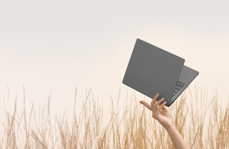 Szary laptop Zenbook A14 można łatwo podnieść kilkoma palcami. Komputer ma lekko otwartą pokrywę pod kątem około 40 stopni z ustawieniem w kierunku prawego górnego rogu.
