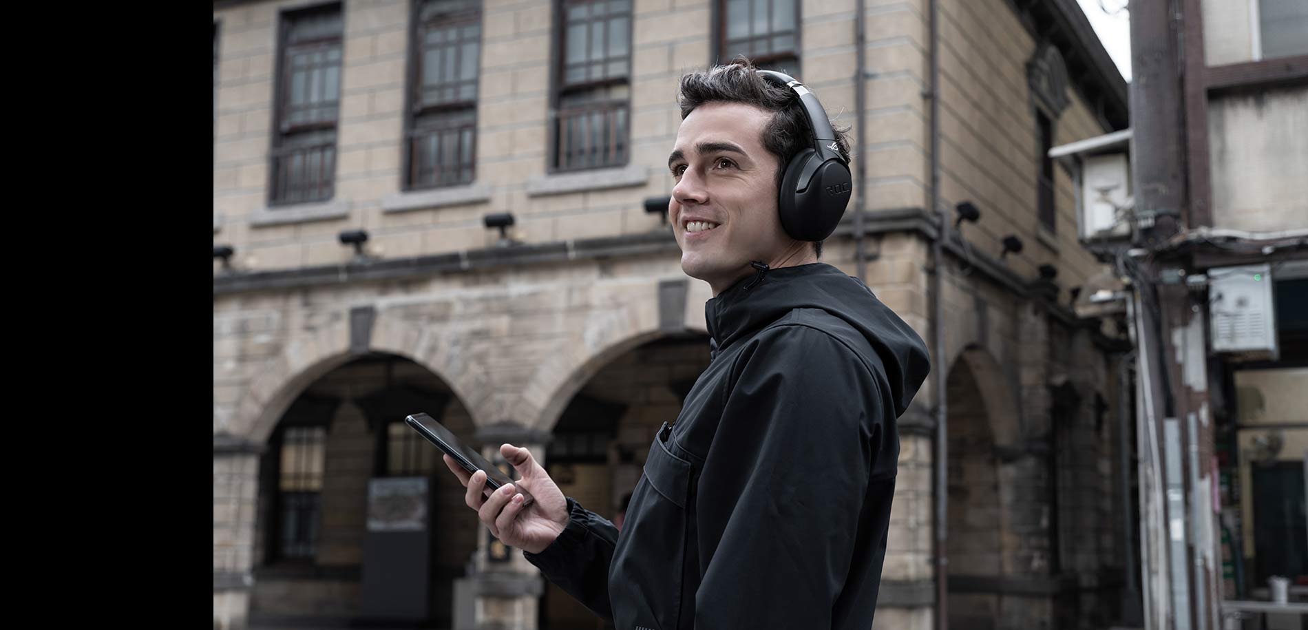 scenario photo demonstrates model is wearing the ROG Strix Go BT, ROG wireless gaming headset, and the phone in hand.