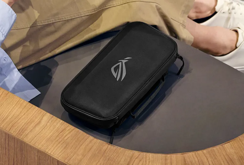 A person sitting next to an ROG Xbox Ally (2-in-1) Premium Case.