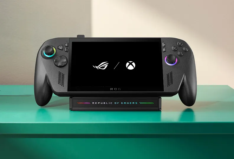 And ROG Xbox Ally X mounted atop an ROG Bulwark Dock on a green table.