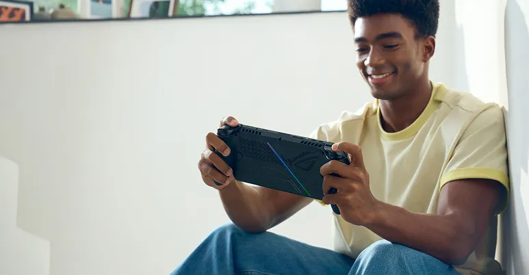 A person in a yellow shirt playing with an ROG Xbox Ally X.