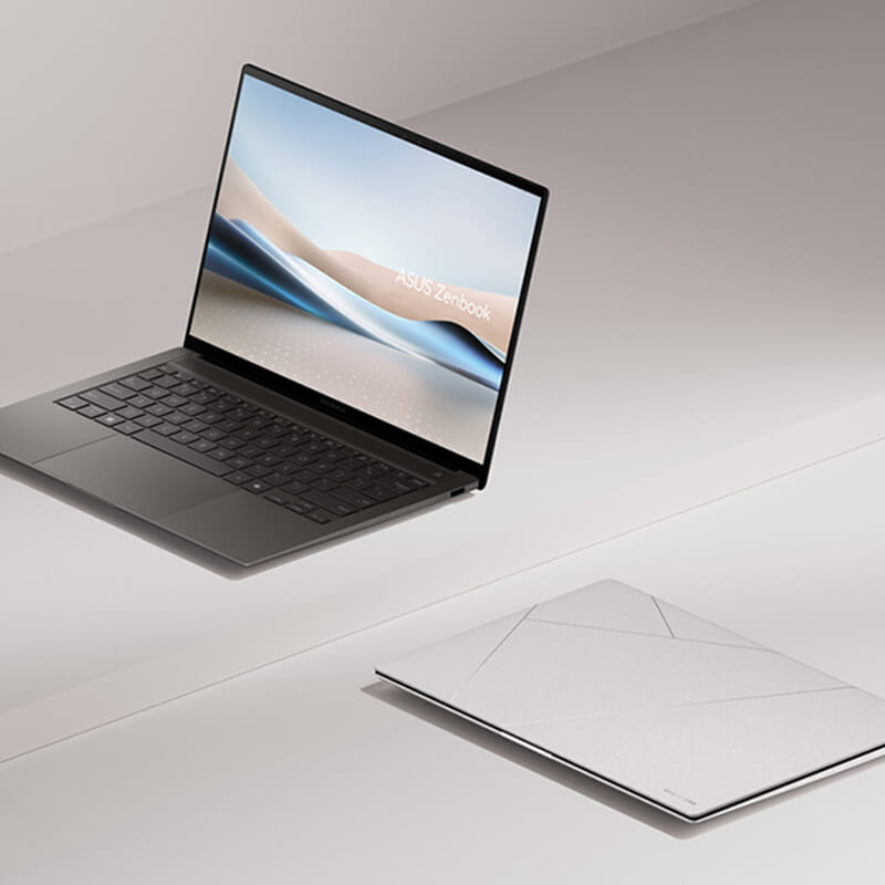 Two Zenbook S 14, one of them opened at 100 degrees and viewed from the left-front, while the other one is closed and placed on the ground.