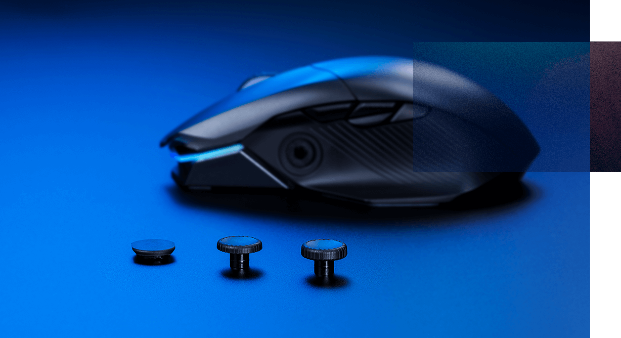 Une photo montrant le côté de la souris, joystick retiré de son support. Deux joysticks de longueurs différentes et le couvercle de la prise se trouvent devant la souris.