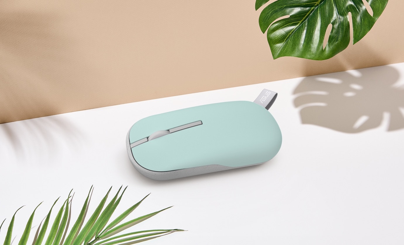 A Brave Green ASUS Marshmallow Mouse MD100 is placed on the table with leaf in the corner.