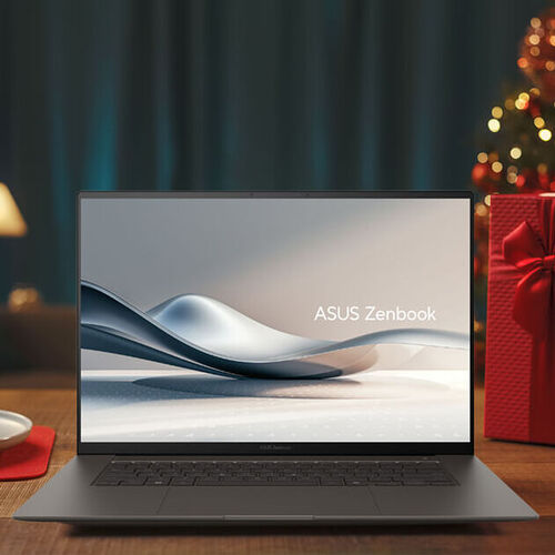 An ASUS Zenbook is placed on a wooden table with holiday decorations around it and in the background.