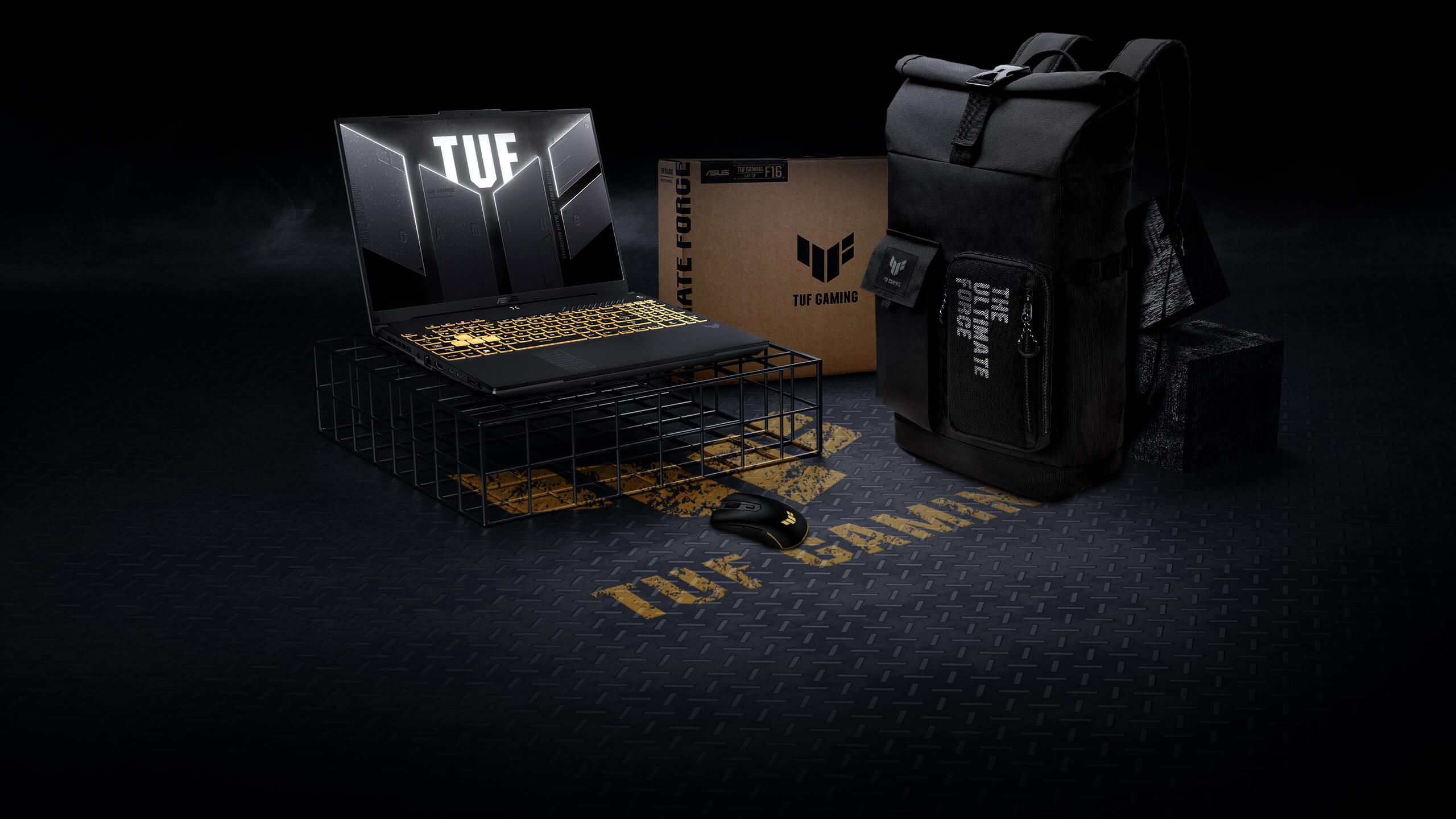 Ноутбук TUF Gaming F16 стоит на проволочной подставке. Рядом с ним находятся мышь и рюкзак серии TUF Gaming.