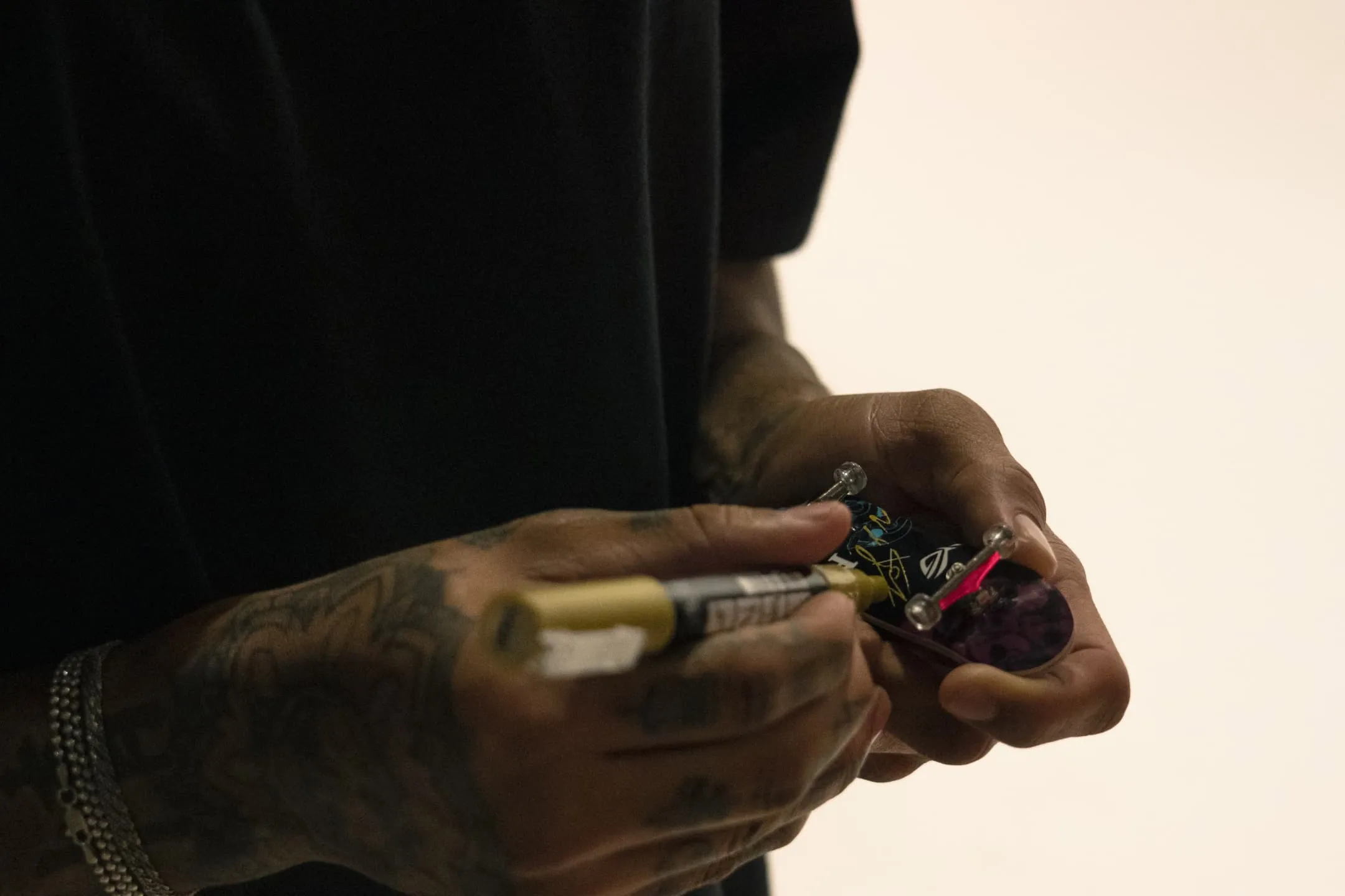 A close up of NYJAH HUSTON signing on a Finger Skate Board toy.