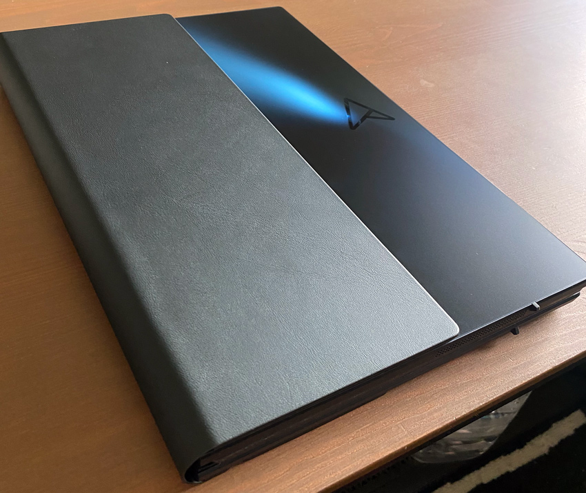 El ASUS Zenbook 17 Fold OLED completamente plegable tiene un cuerpo azul metálico con un nuevo logotipo de monograma ASUS y una cubierta de piel que también sirve como un soporte