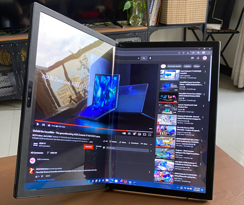 ASUS Zenbook 17 Fold OLED screen displaying a YouTube video while partially folded in the Reader Mode, placed on my living room coffee table