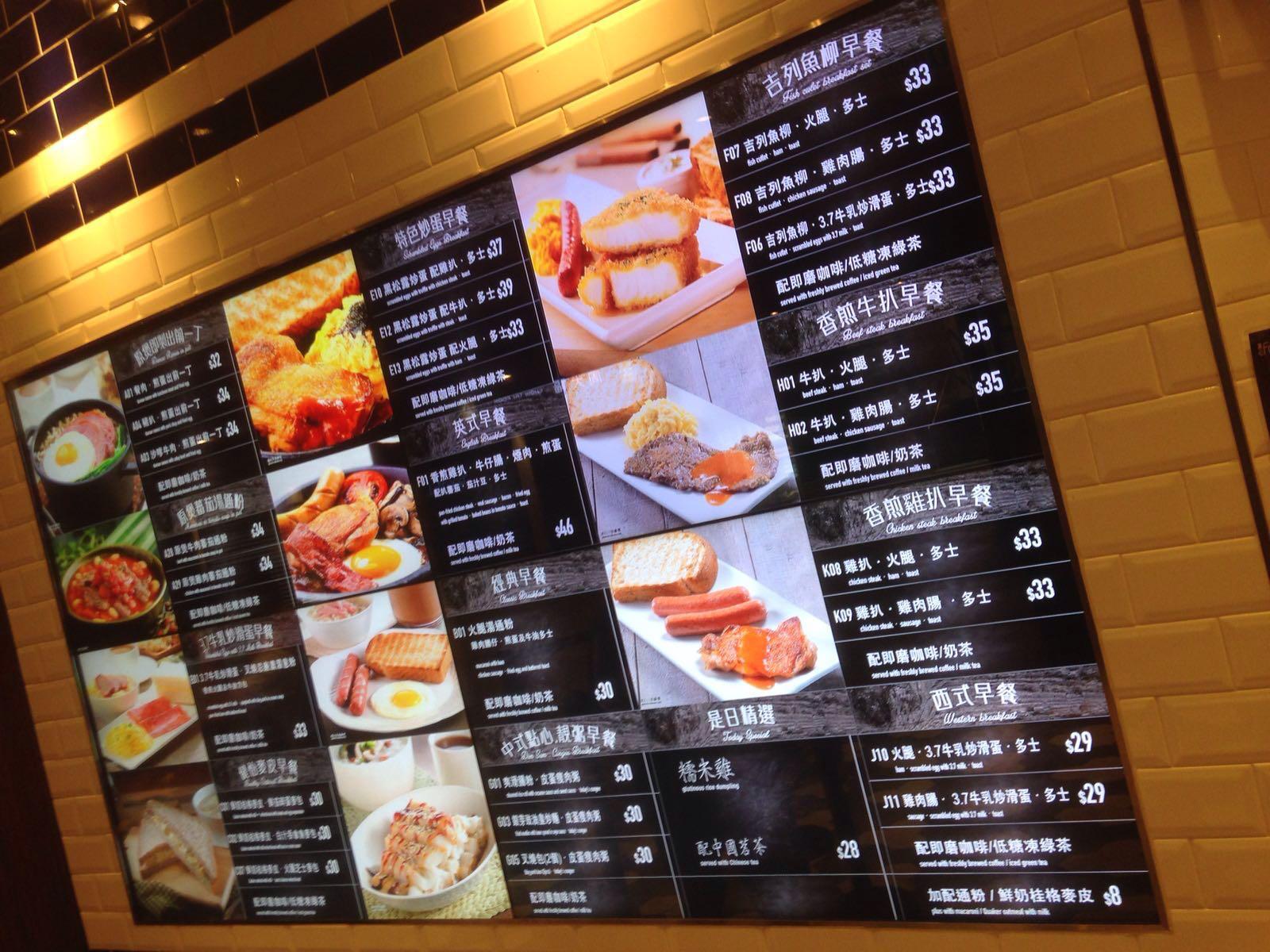 A brightly lit menu with multiple sections displaying images of breakfast dishes, including eggs, sausages, toast, and rice, with prices in a tiled setting.