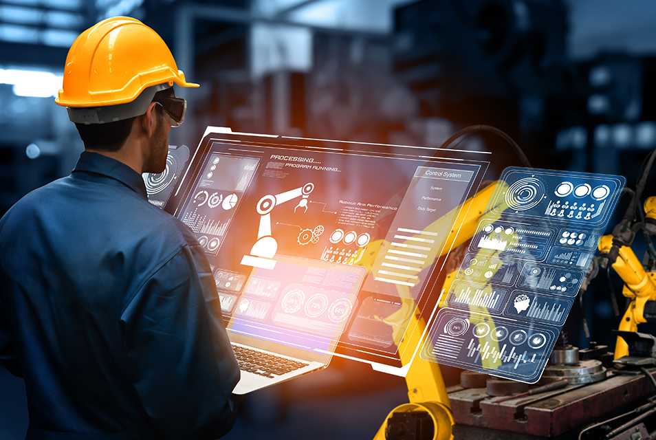 A worker in a hard hat interacts with a transparent screen displaying robotic and analytical data in an industrial setting, conveying innovation.