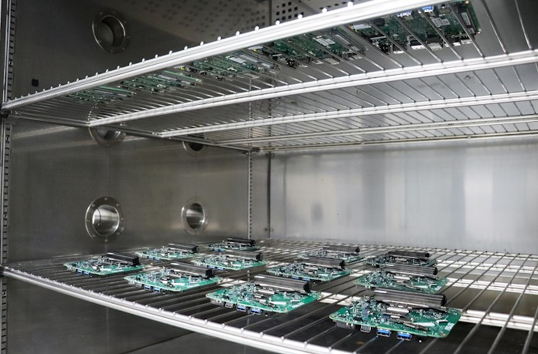 NUC Mini PC Thermal Bake Test NUC best quality mini PC testing of thermal bake test. Eleven green and black electronic components are placed in an oven-like environment on a wire mesh.