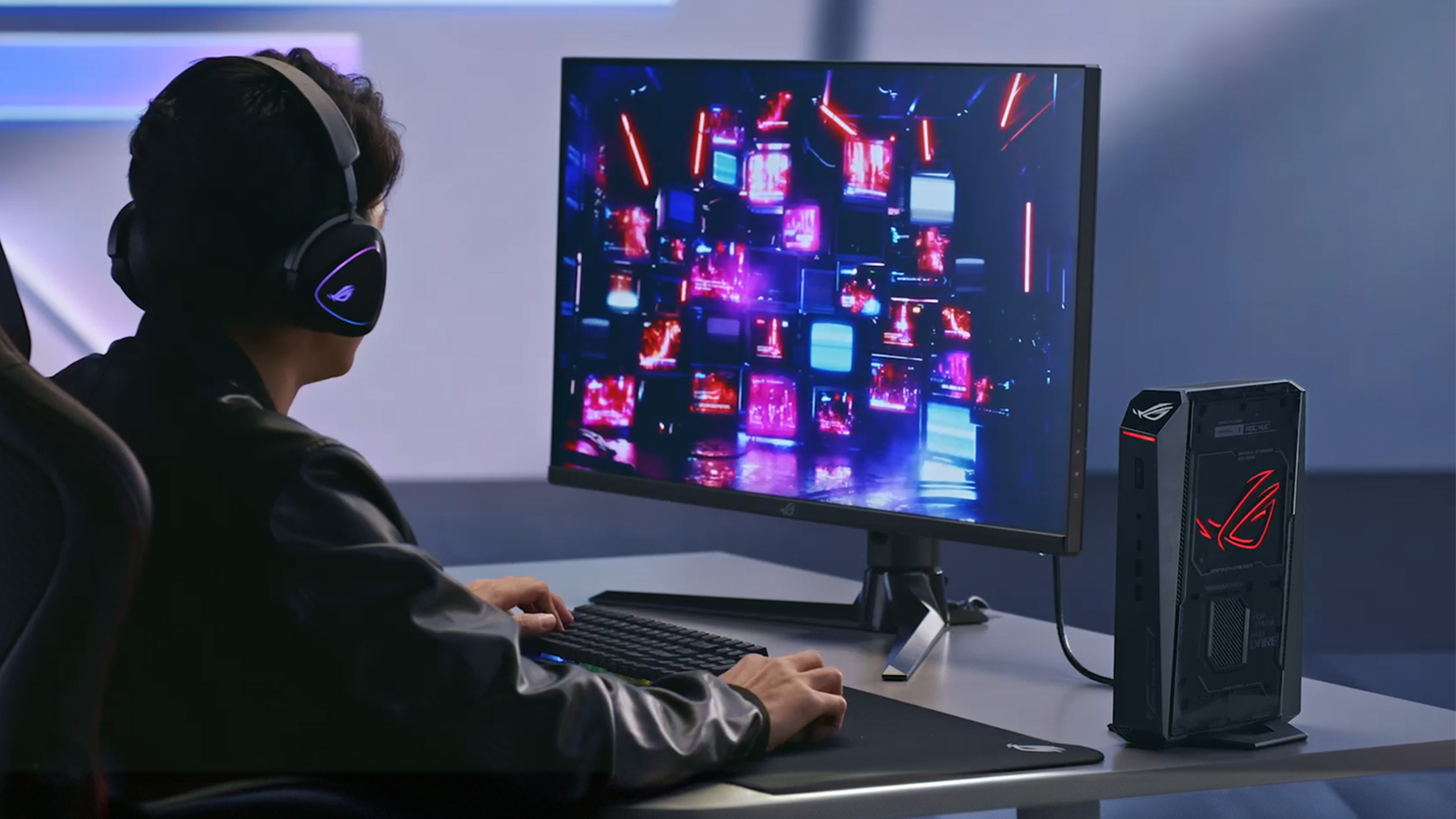 Gamer wearing headphones at desk using compact ROG NUC gaming mini PC for high-performance gameplay. 