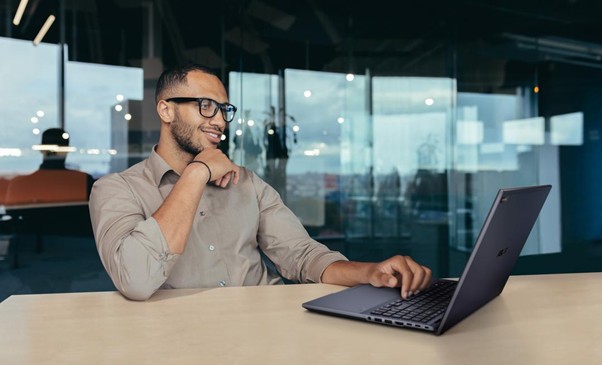 Homem sentado em um escritório usando notebook, representando produtividade, associado ao conceito de o que é IA generativa.