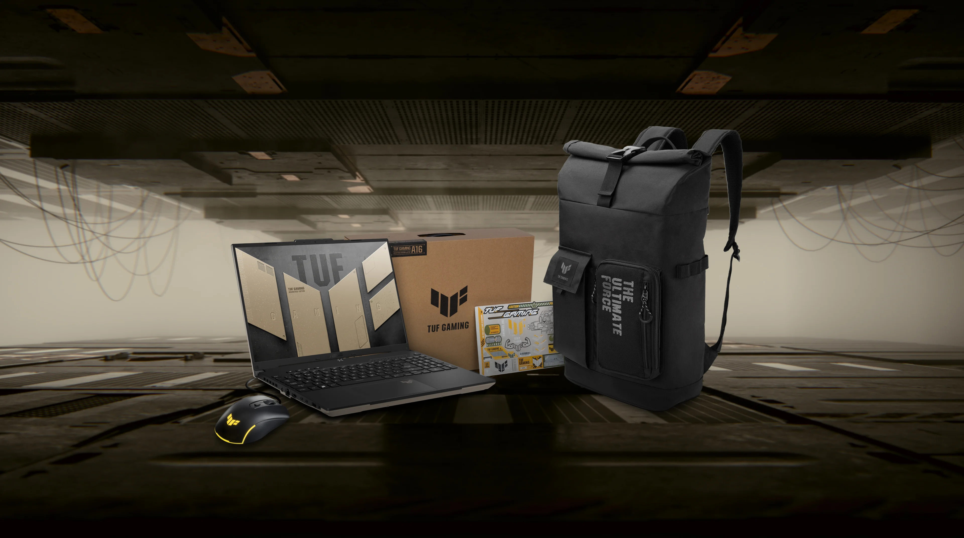 De TUF Gaming A16 laptop naast de muis, rugzak en doos met TUF-sticker.
