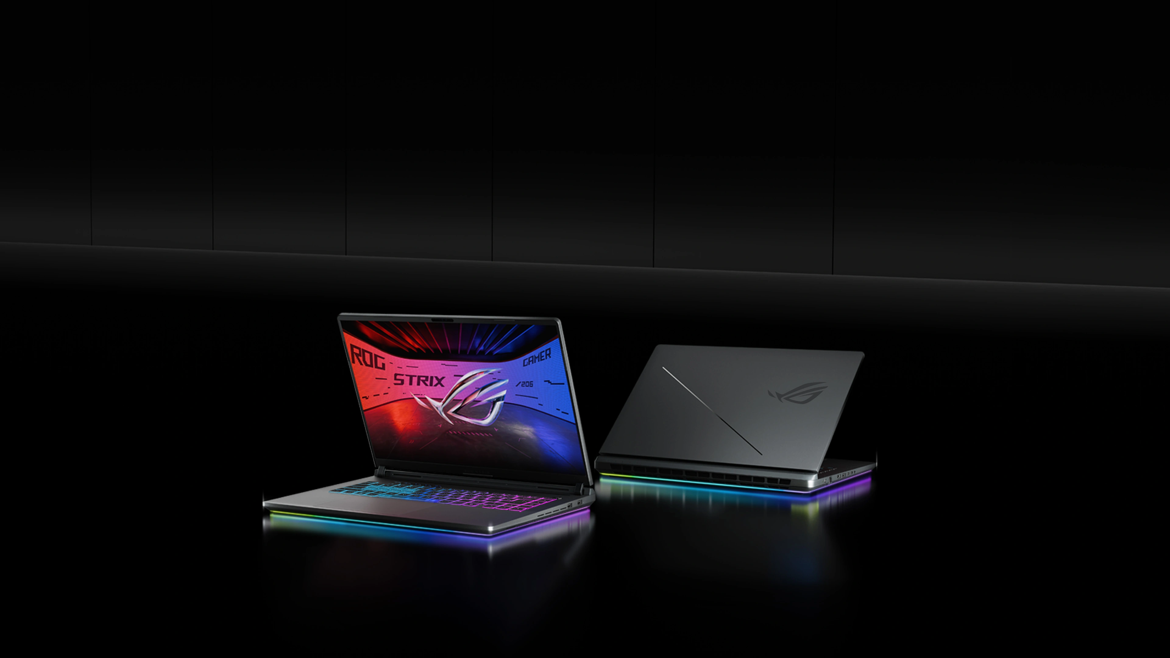 Two ROG Strix laptops on a table with the lids partially opened.