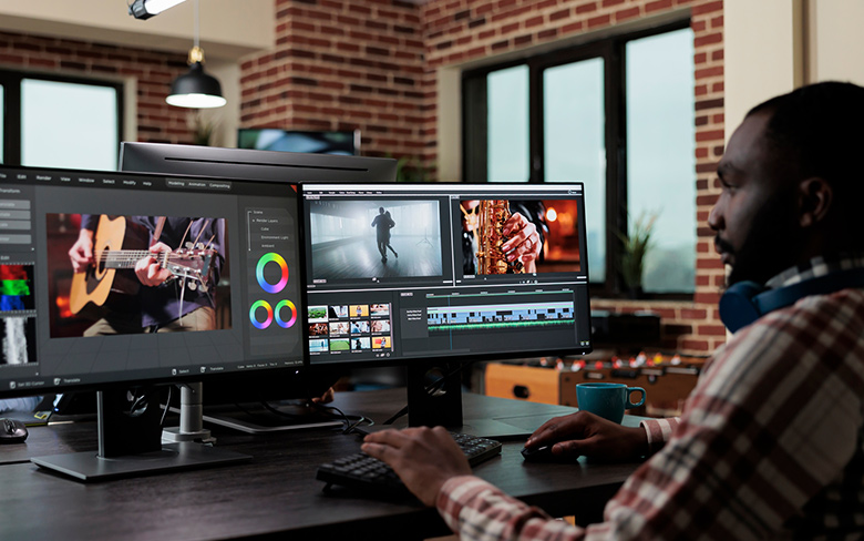 African american creative digital video editor sitting at desk while improving recorded footage visual quality.