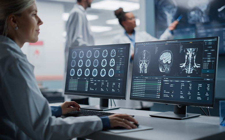 Medical Hospital Health Care Lab: Portrait of Female Medical Scientist Using Computer with Brain Scan MRI Images, Finding Cure.