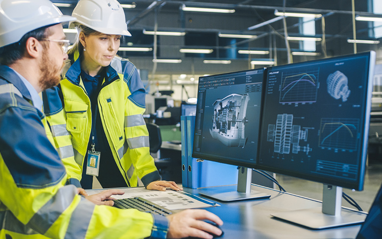 Electronics Design Factory Office: two Engineers Wearing Safety Vest Working on Computer, Developing Industrial Microchips.