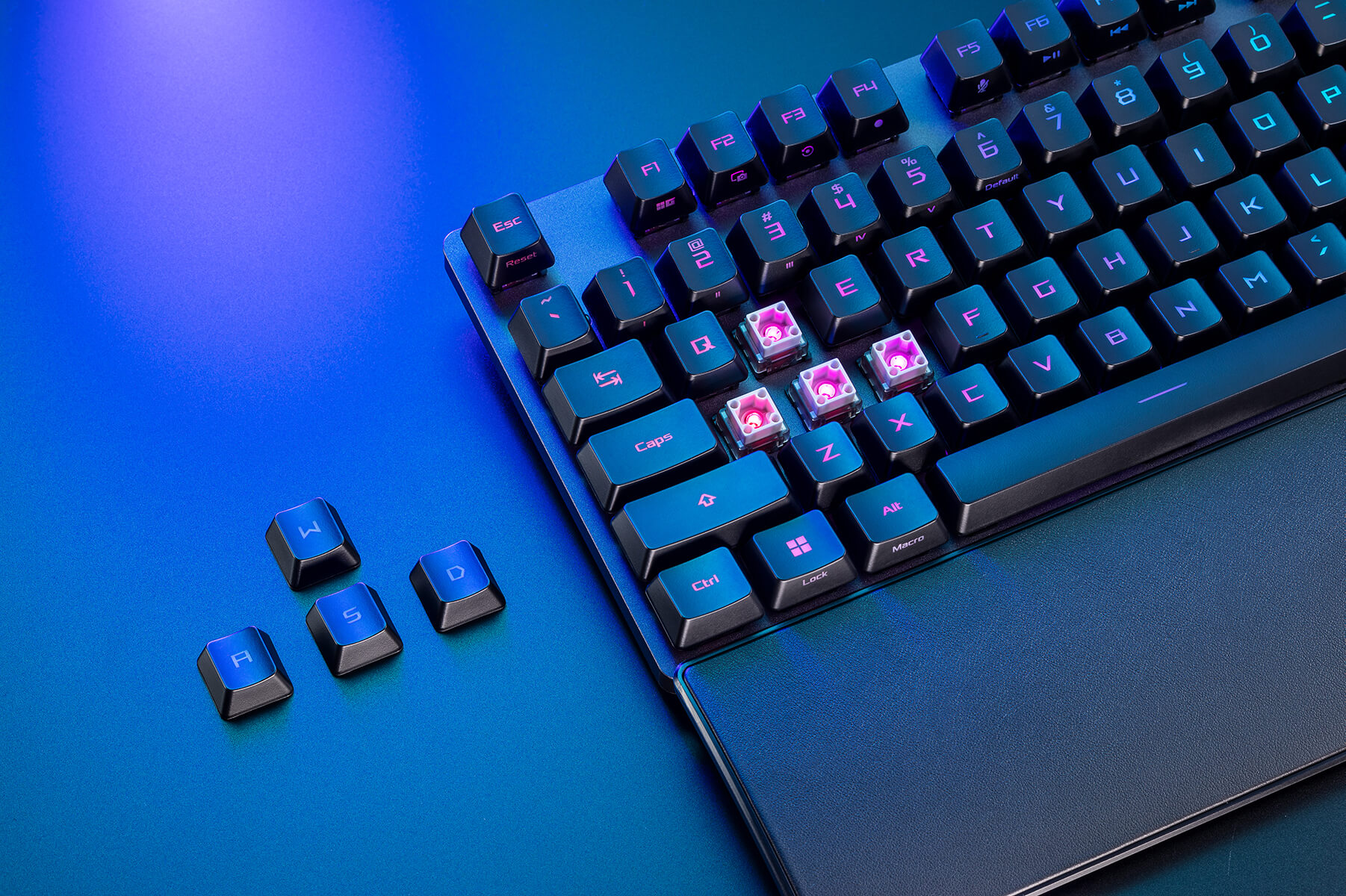 Close-up on the left area of ROG Strix Scope II RX on a table with some keycaps removed showing the ROG RX optical switches