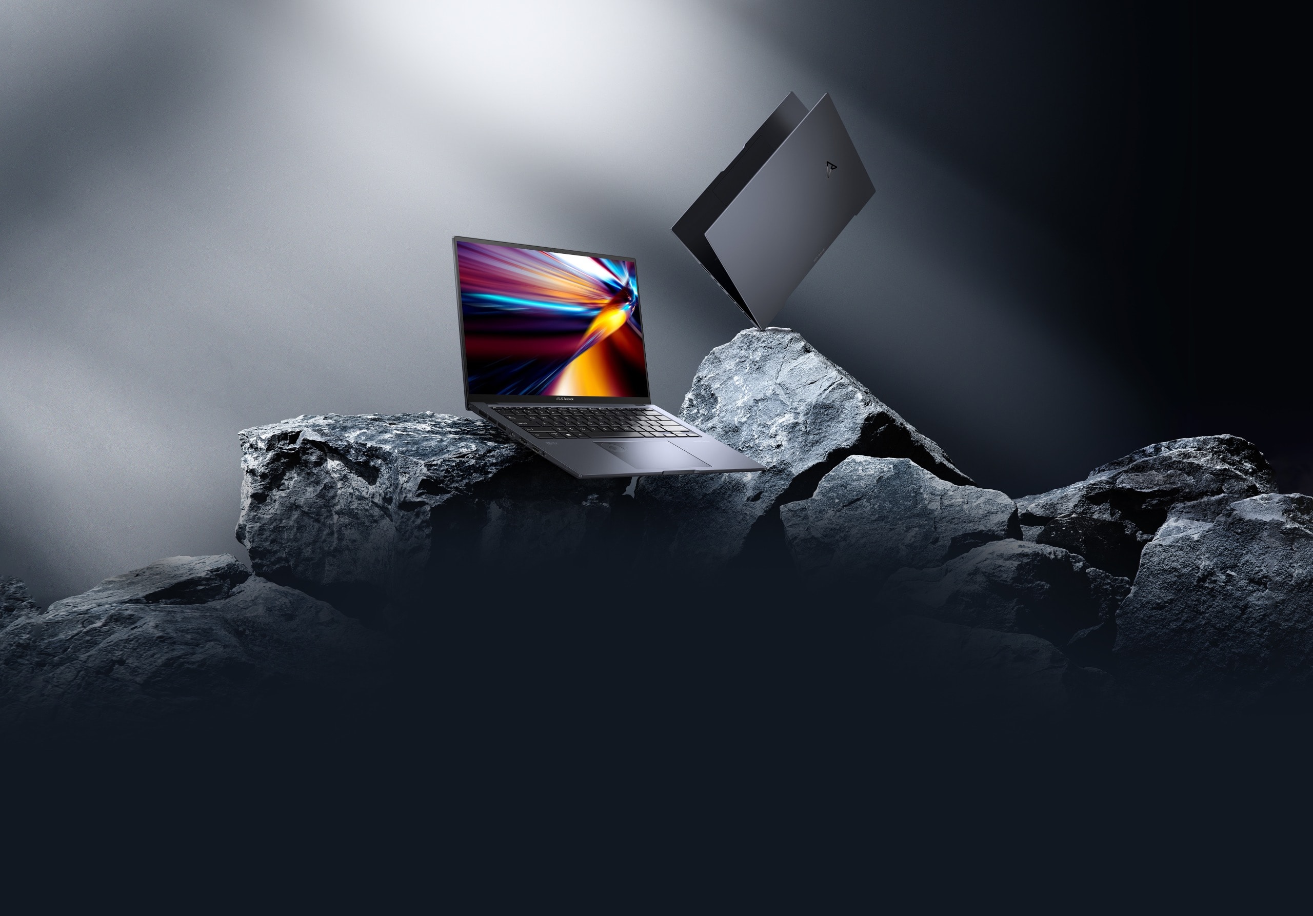   Zenbook Pro 14 OLED 開啟 45 度，斜置於黑色岩石