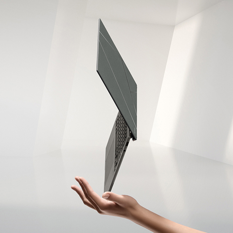 Zenbook S 13 OLED floating in the palm of a hand standing on its corner with an Evo badge by its side.
