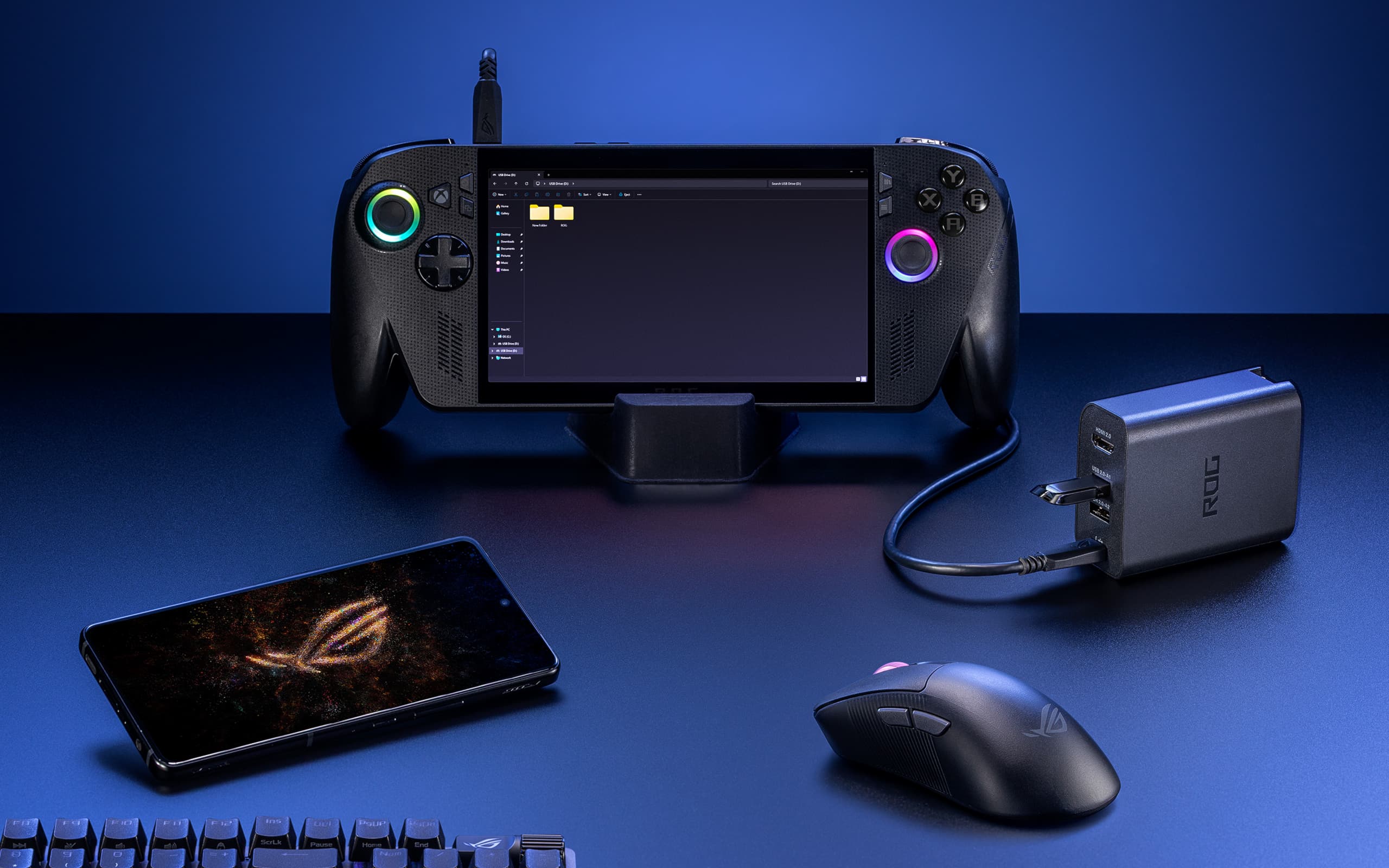 An ROG 100W Gaming Charger Dock plugged into both an ROG Phone 9 Pro and ROG Xbox Ally X, notably just via USB and not connected to AC power.