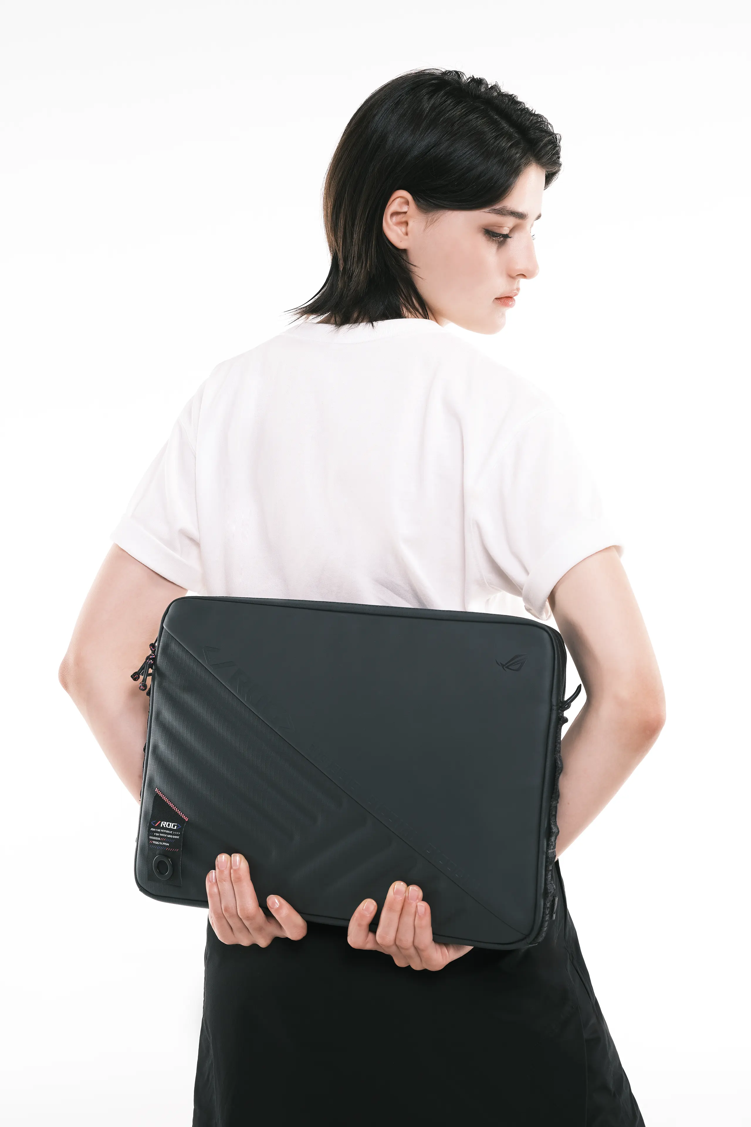 A person looking over their shoulder and holding the ROG SLASH Sleeve Bag 4.0 behind their back.