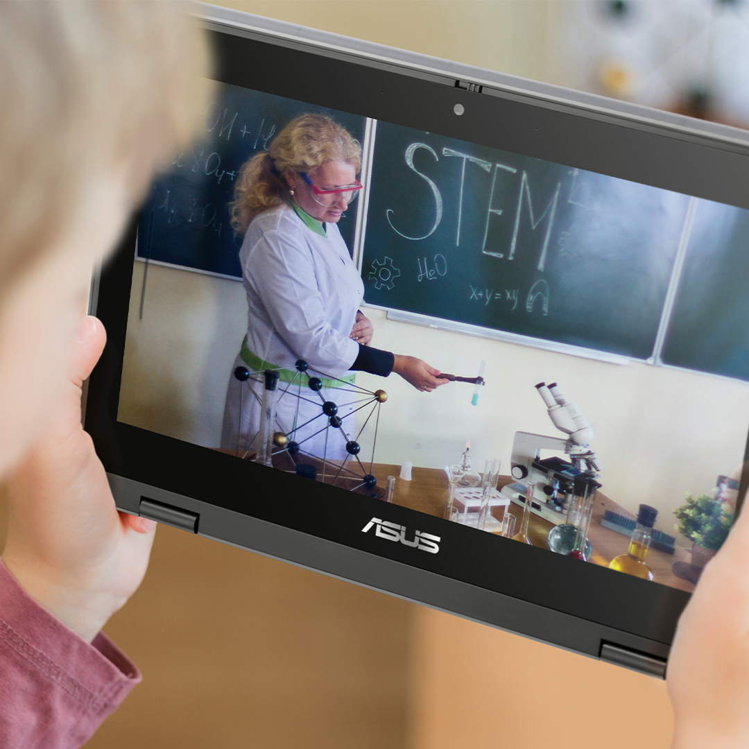A boy is recording a teacher doing experiment with an ASUS BR1100F laptop in tablet mode.