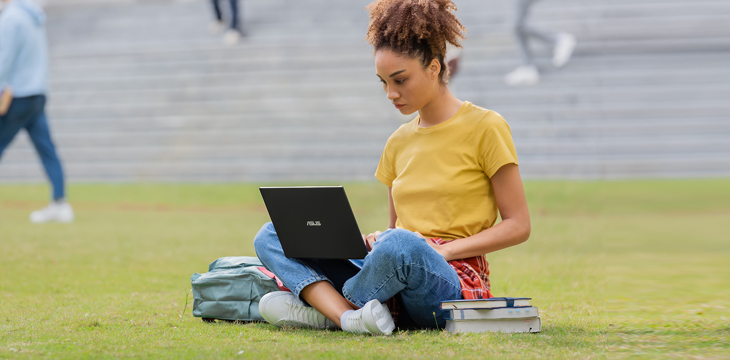 Dvaja študenti univerzity sedia vonku a spoločne používajú ASUS Chromebook.