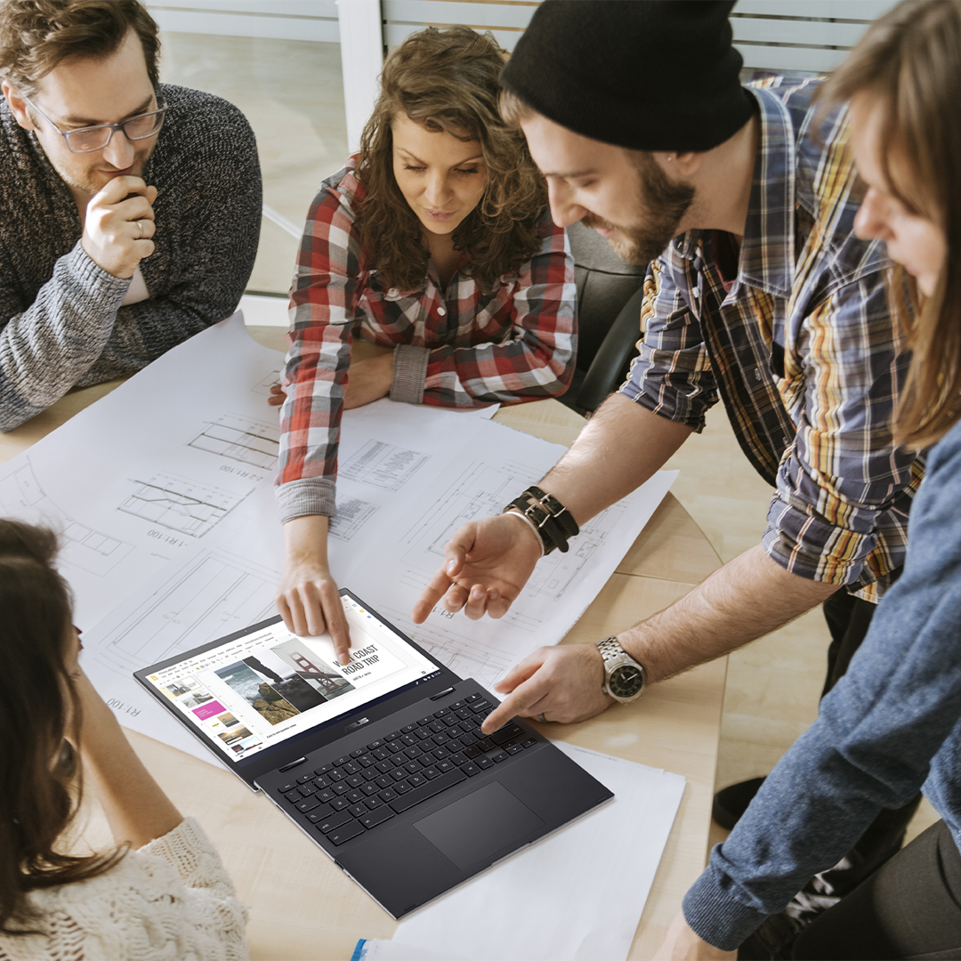 Een groep jongeren zit samen te discussiëren, kijkend naar een ASUS Chromebook die in 180 graden plat open op het bureau ligt.