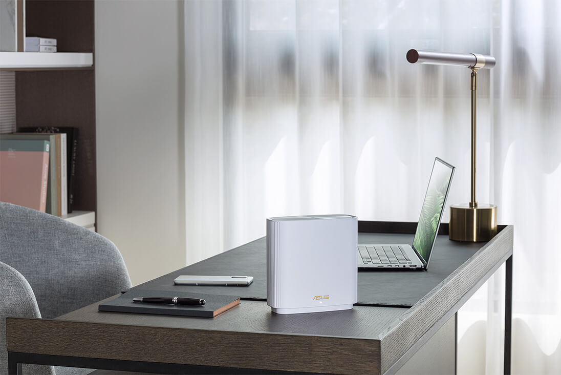 Une photo de scénario montrant le ZenWiFi, l'ordinateur portable et le Zenfone d'ASUS sur le bureau.