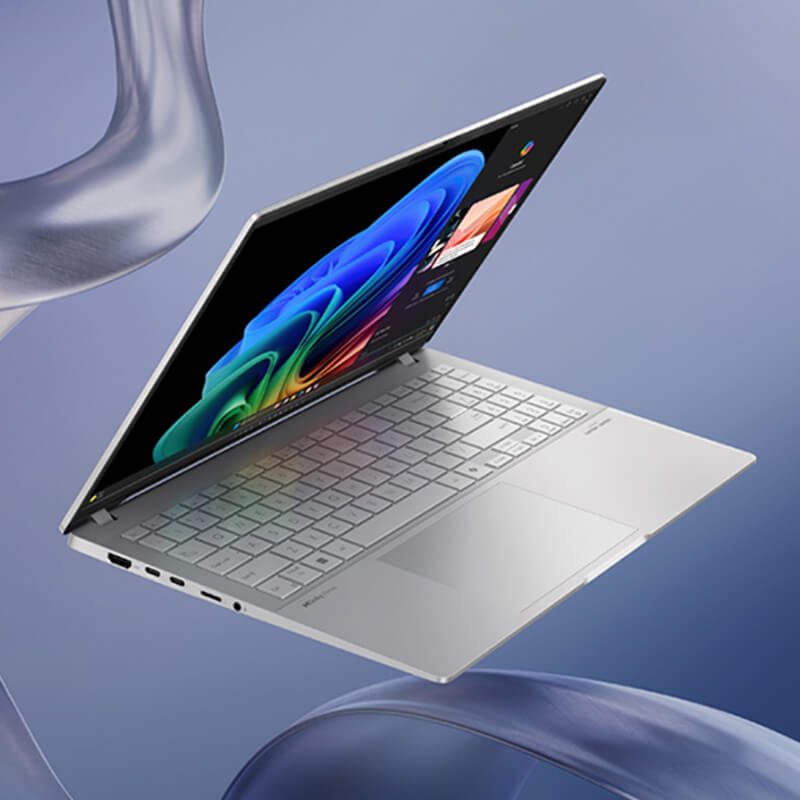 A silver ASUS Vivobook is opened halfway while floating in mid-air with a strand of flowy silk running beside it.