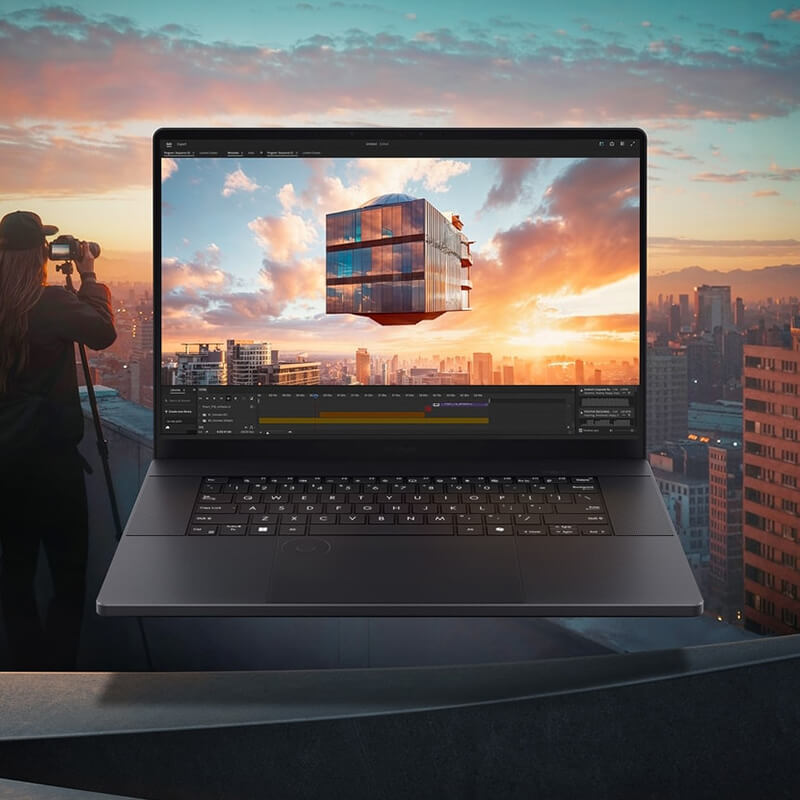 ProArt P16 laptop open with a video editing software window on screen and a city during sunset in the background.