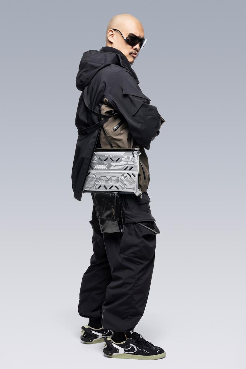 Off center photo of Errolson Hugh wearing the RMT02 in across his side and wearing the classic ACRNM jacket.