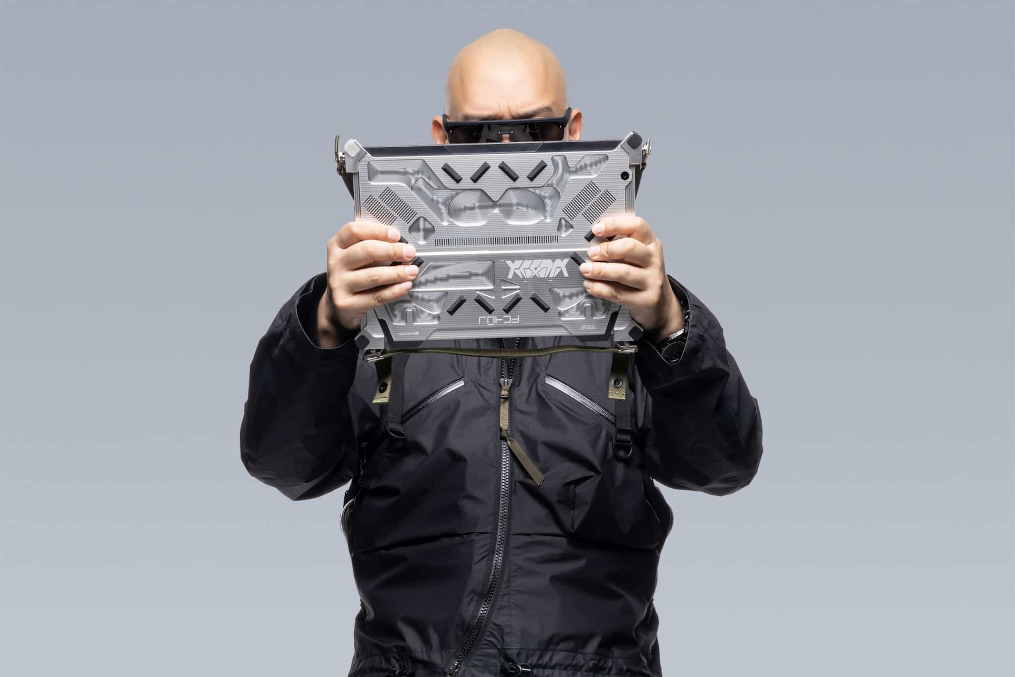 ACRNM creative director Errolson holding the RMT02, with just his eyes and top of his head visible.