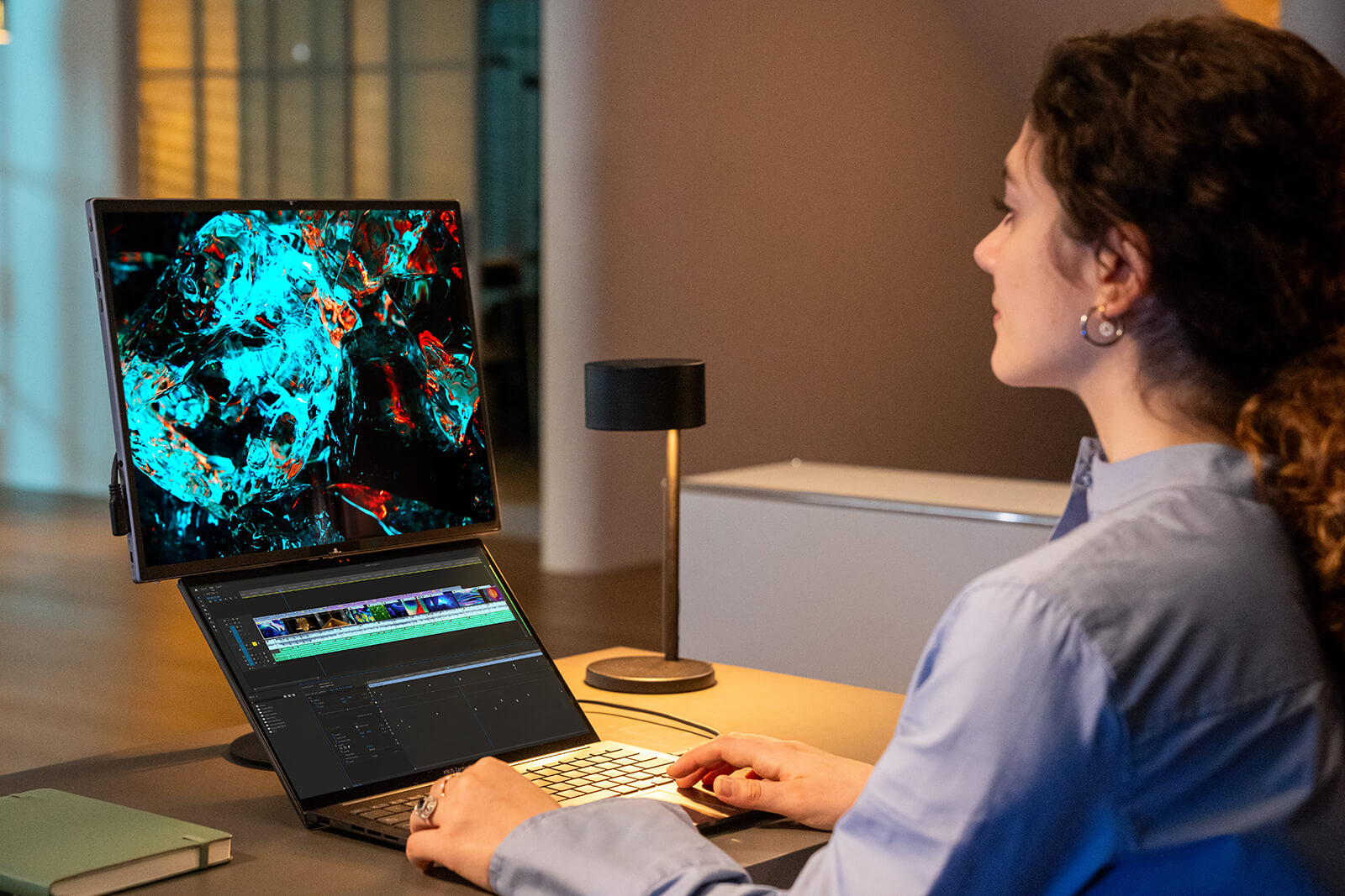 A young girl works on video editing, with laptop connects to the MQ17QH portable monitor that mounts on the MTS02D portable monitor tripod stand, display in landscape mode