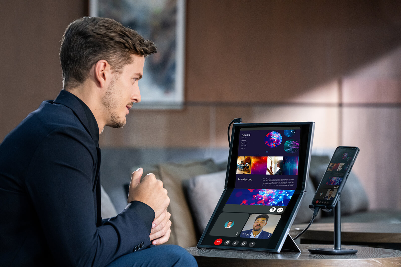 A young businessman has online meeting outside, connecting his phone to the MQ17QH portable monitor in portrait mode for seeing more clearly on a bigger screen