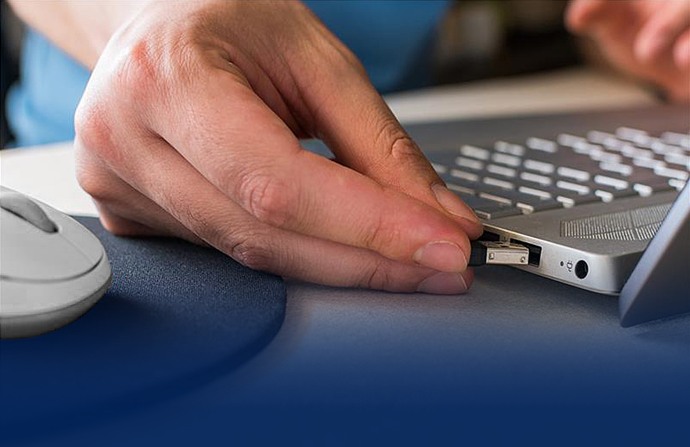 A user is plugging the USB-BT540 into the laptop to show easy connection.