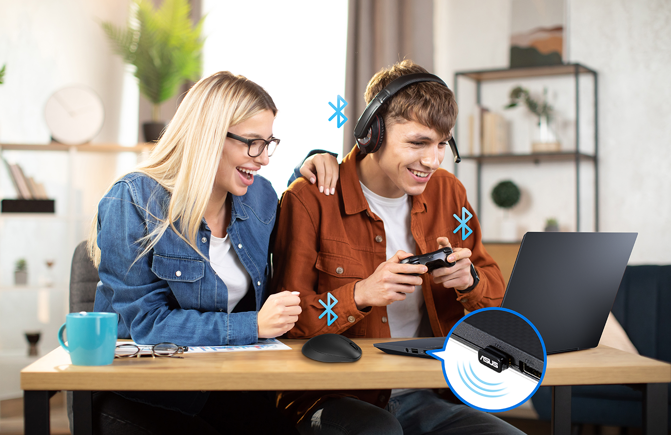 Two people are playing video games with all their wireless devices connected with the laptop through the USB-BT540.