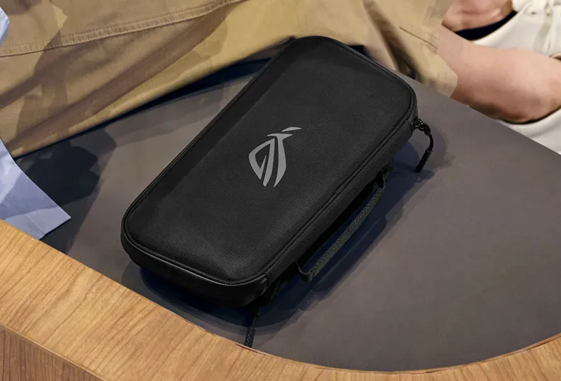A person sitting next to an ROG Xbox Ally (2-in-1) Premium Case.