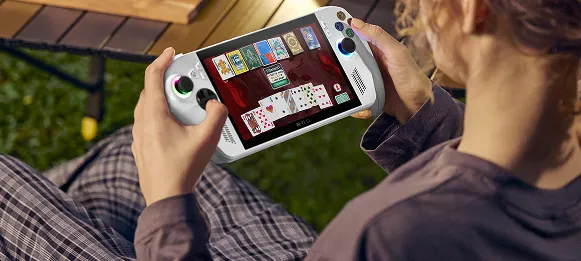 A person outdoors on a wooden bench playing with the ROG Xbox Ally.
