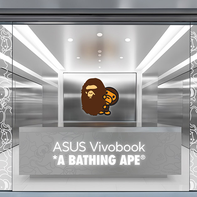 the view of the store front of the ASUS Vivobook and A Bathing APE collaboration laptop popup store, with the BABY MILO hiding behind BAPE logo and the ASUS Vivobook and A BATHING APE logotype on metal background with subtle camo design pattern, Title: ASUS Vivobook x A BATHING APE®︎