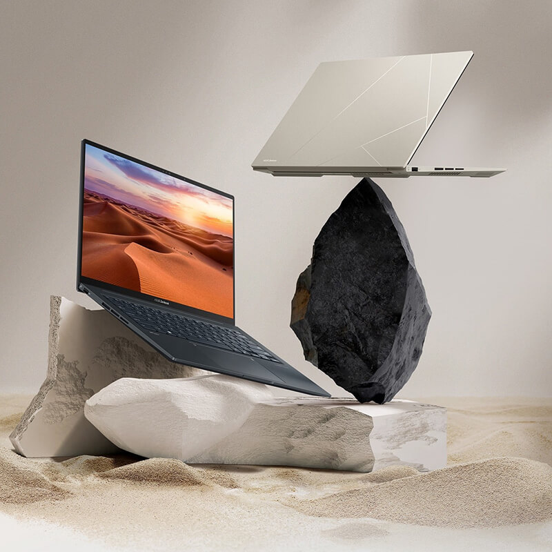 Laptopy Zenbook 14X OLED w kolorach czarnym i beżowym. Model czarny jest pokazany z szeroko otwartą pokrywą na skale z piaskowca, a beżowy w widoku od tyłu na czarnej skale.