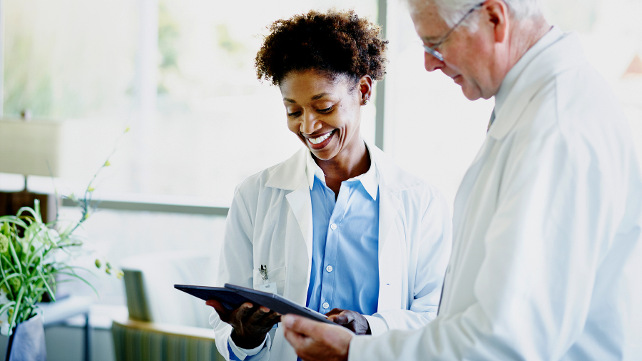 Deux médecins regardent leur ordinateur portable ASUS ExpertBook B3 Detachable en souriant.