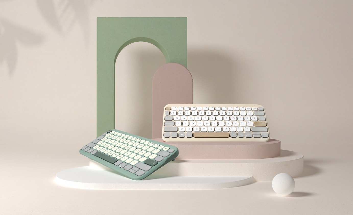 Tweemaal de ASUS Marshmallow Keyboard KW100 naast elkaar om de verschillende kleurstellingen te tonen, met Green Tea Latte aan de linkerkant en Oat Milk aan de rechterkant.