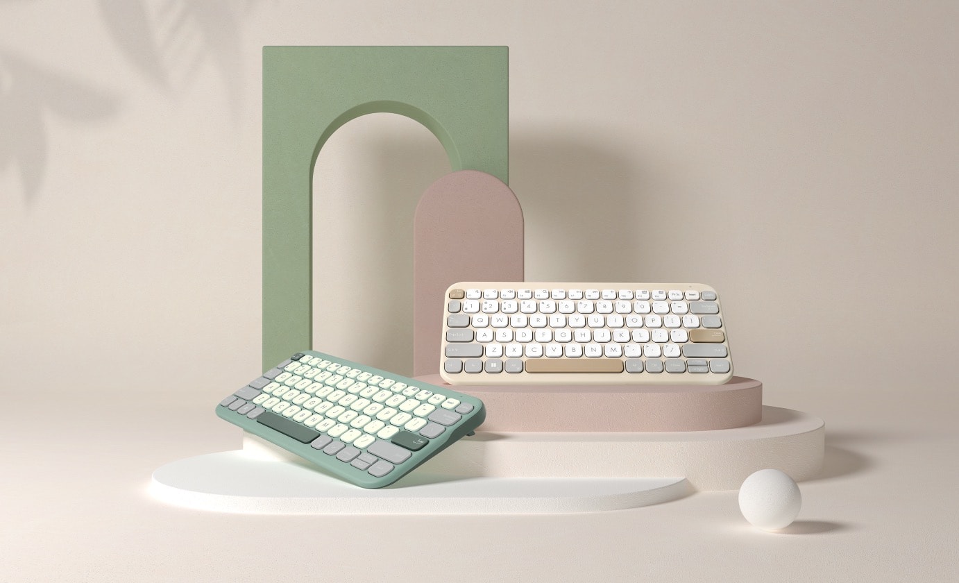 兩個 ASUS Marshmallow Keyboard KW100 並列以呈現不同的配色，包括左側的綠拿鐵以及右側的燕麥奶。