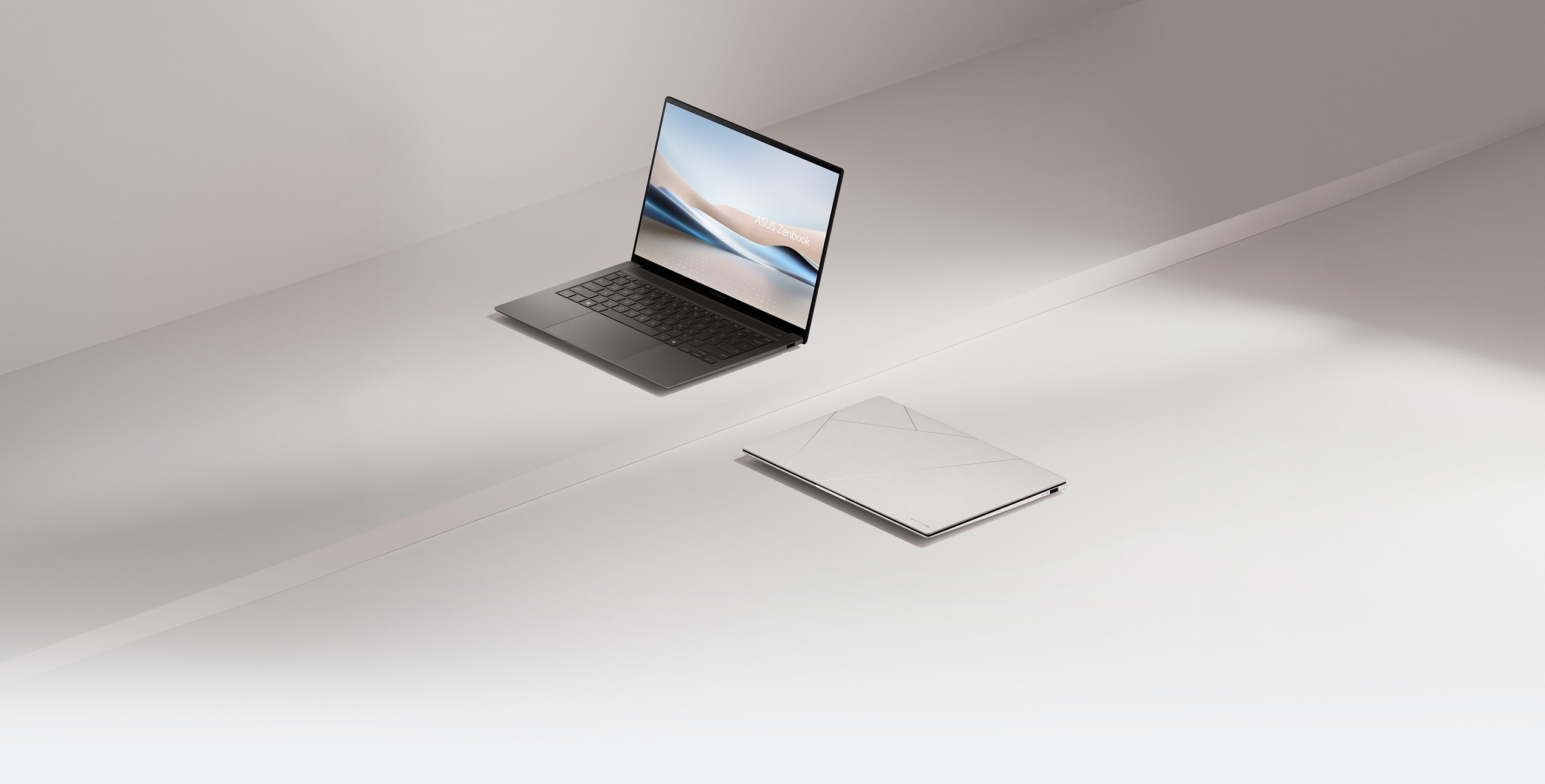 Dos Zenbook S 14, uno de ellos abierto a 100 grados y visto desde el frente izquierdo, mientras que el otro está cerrado y colocado en el suelo.