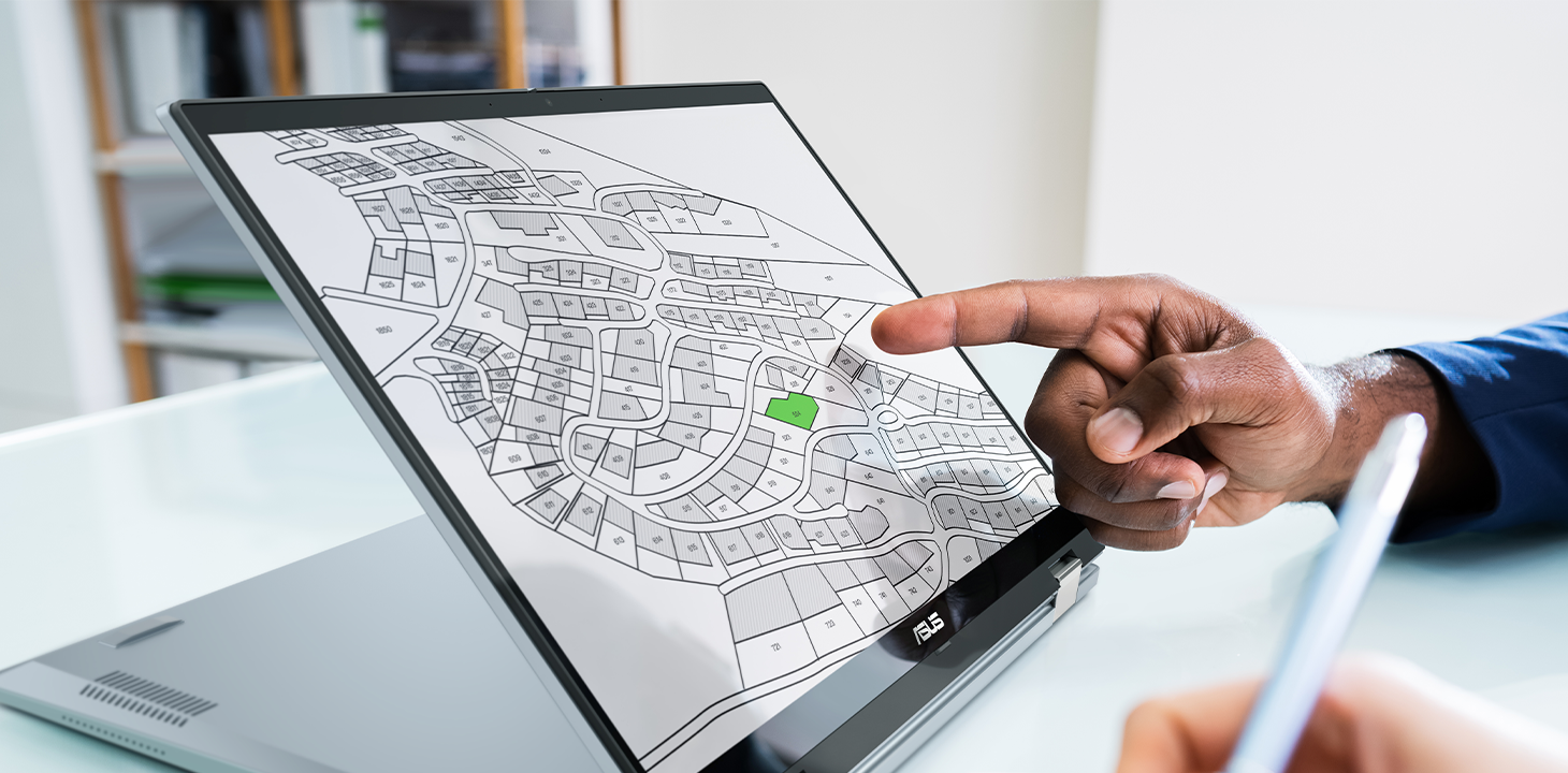 Un dipendente indica un piano di utilizzo del territorio visualizzato su un portatile Chromebook ASUS.