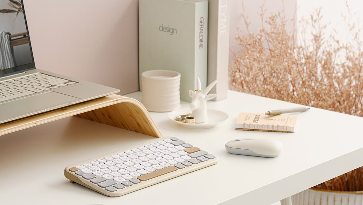 An ASUS Marshmallow keyboard sits on a white desk in front of an ASUS laptop.